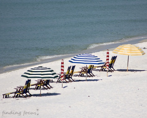 colorful beach umbrellas white sand blue water